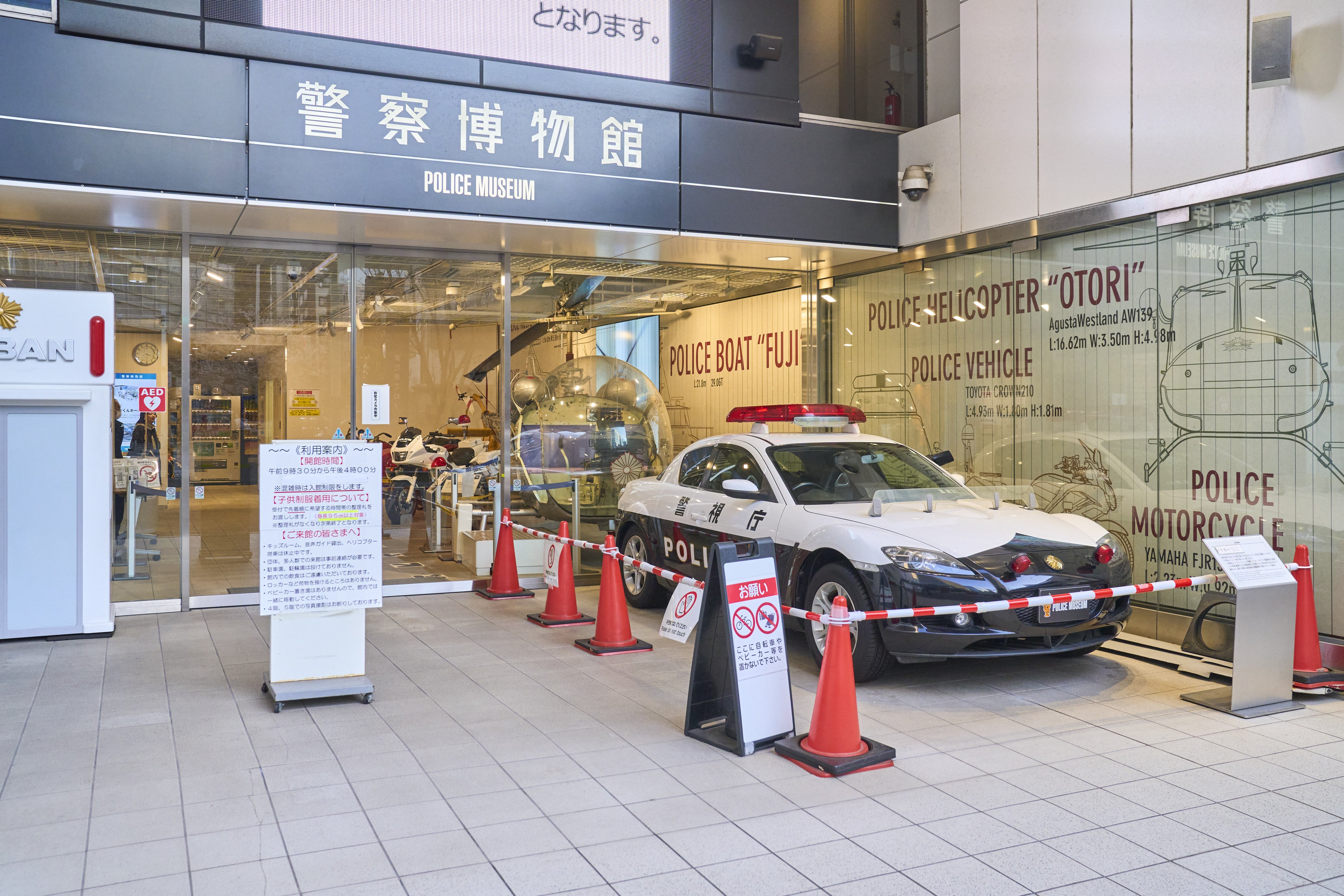 A police car is displayed on the right side of the main entrance.