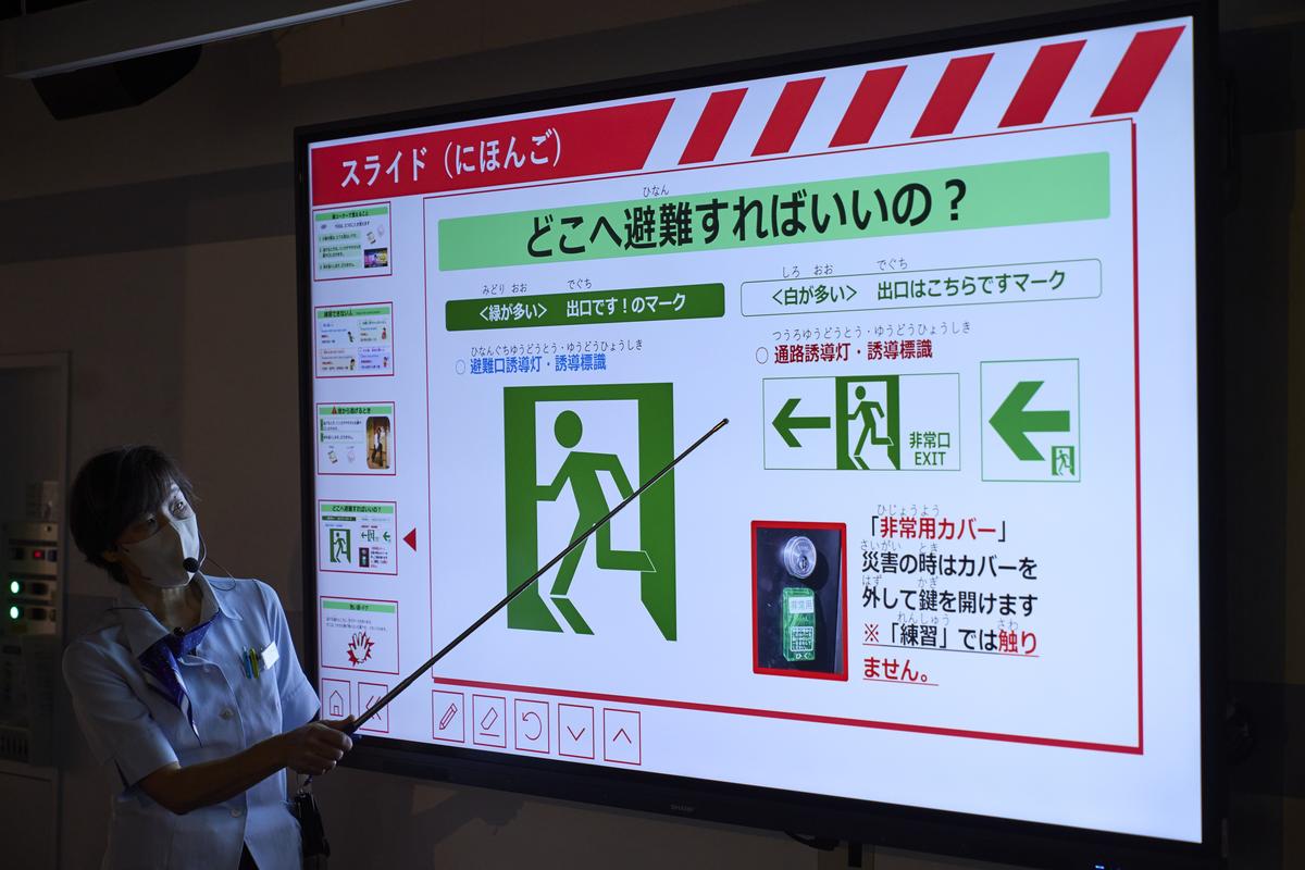 The instructor explains how to follow exit signs to evacuate during a fire.