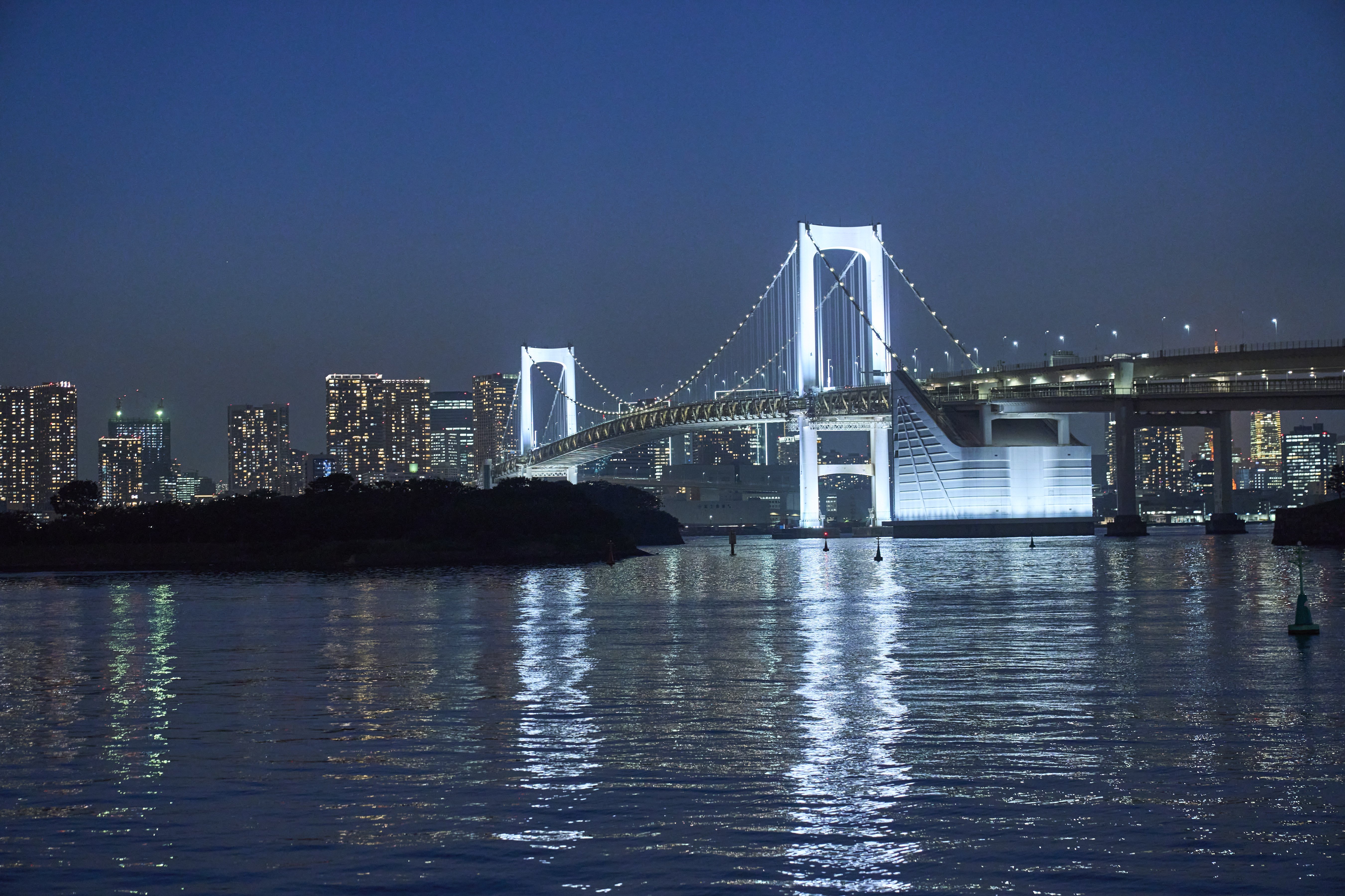 Rainbow Bridge is illuminated at night.