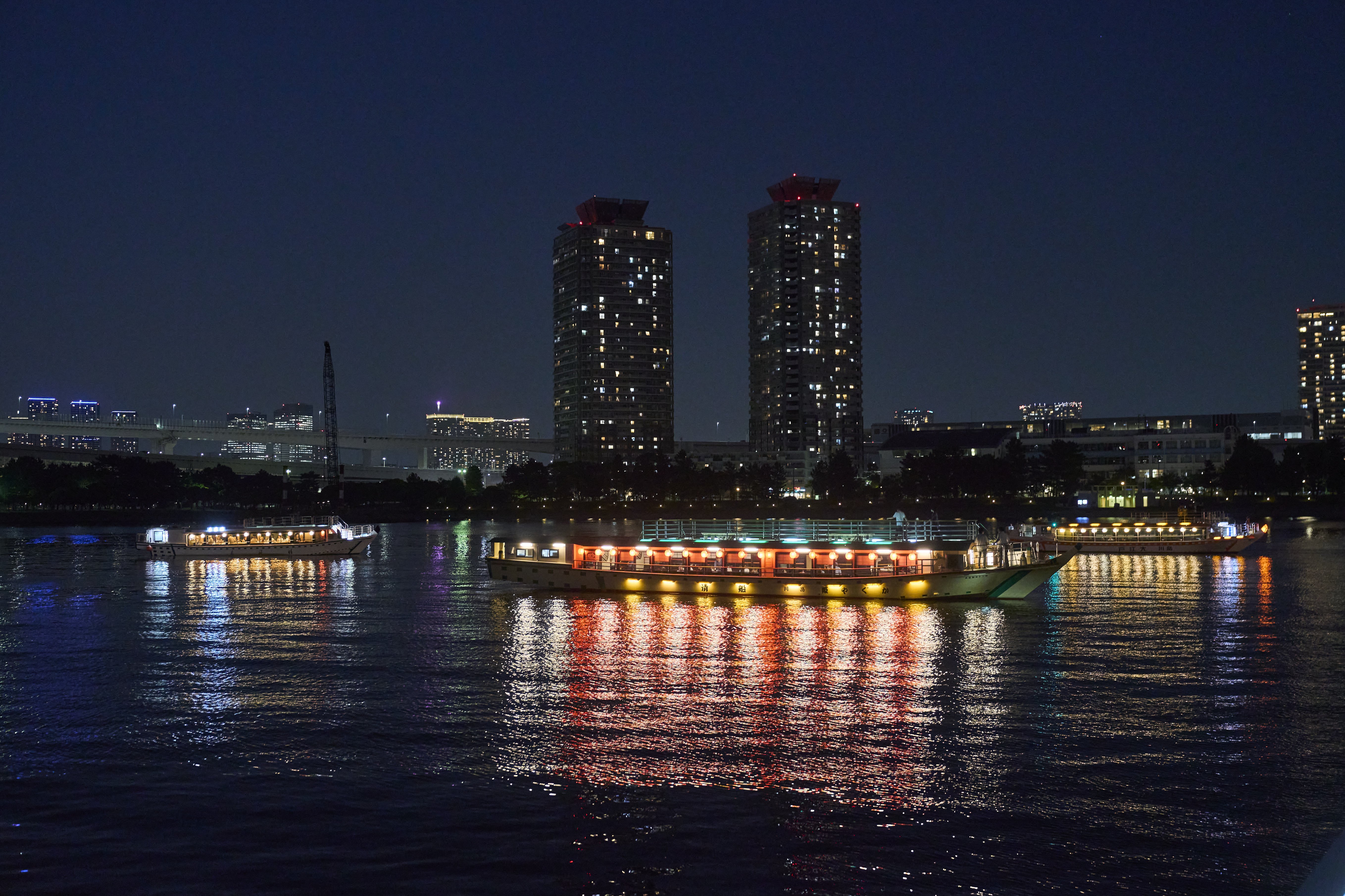 The lights of many yakatabune bring a festive atmosphere to the river.