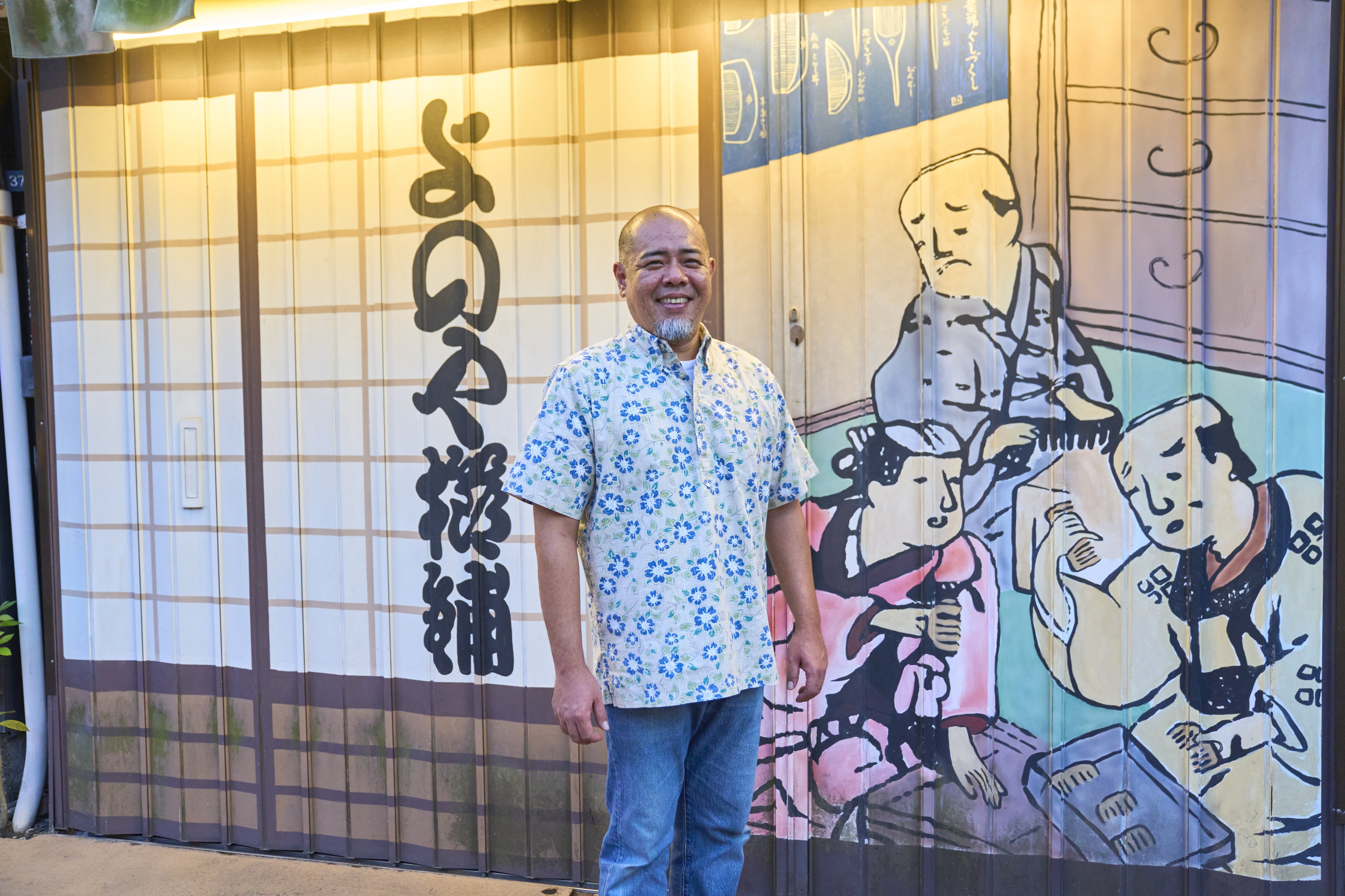 Owner-craftsman Saito Yutaka stands before Yonoya's painted shutters, a modern canvas for a centuries-old tradition.