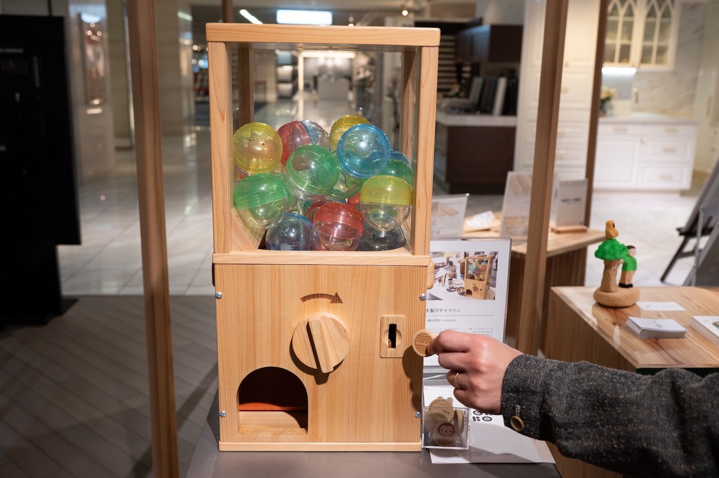 A gacha capsule toy machine made from wood.