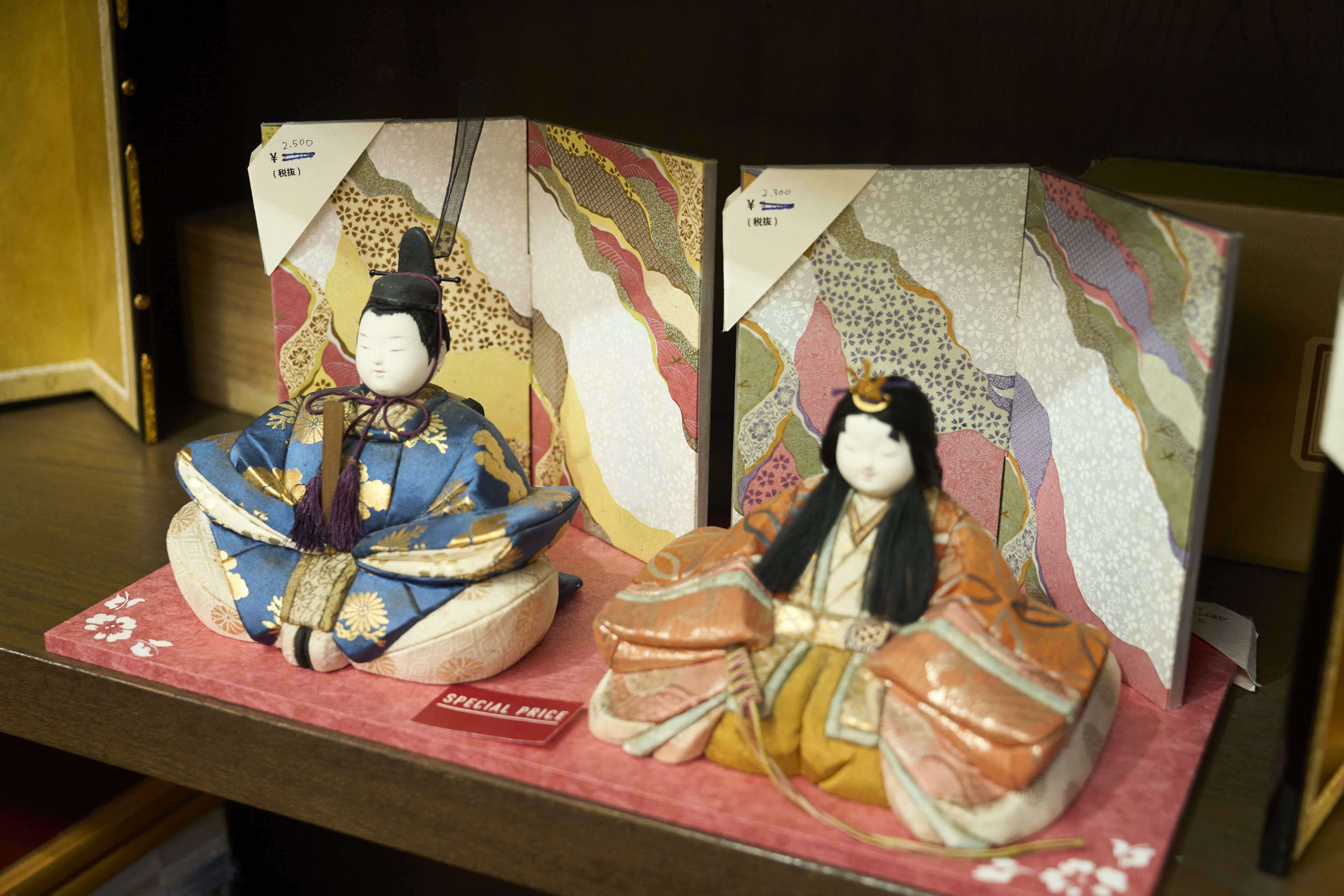 A small byobu displayed behind a set of hina dolls.