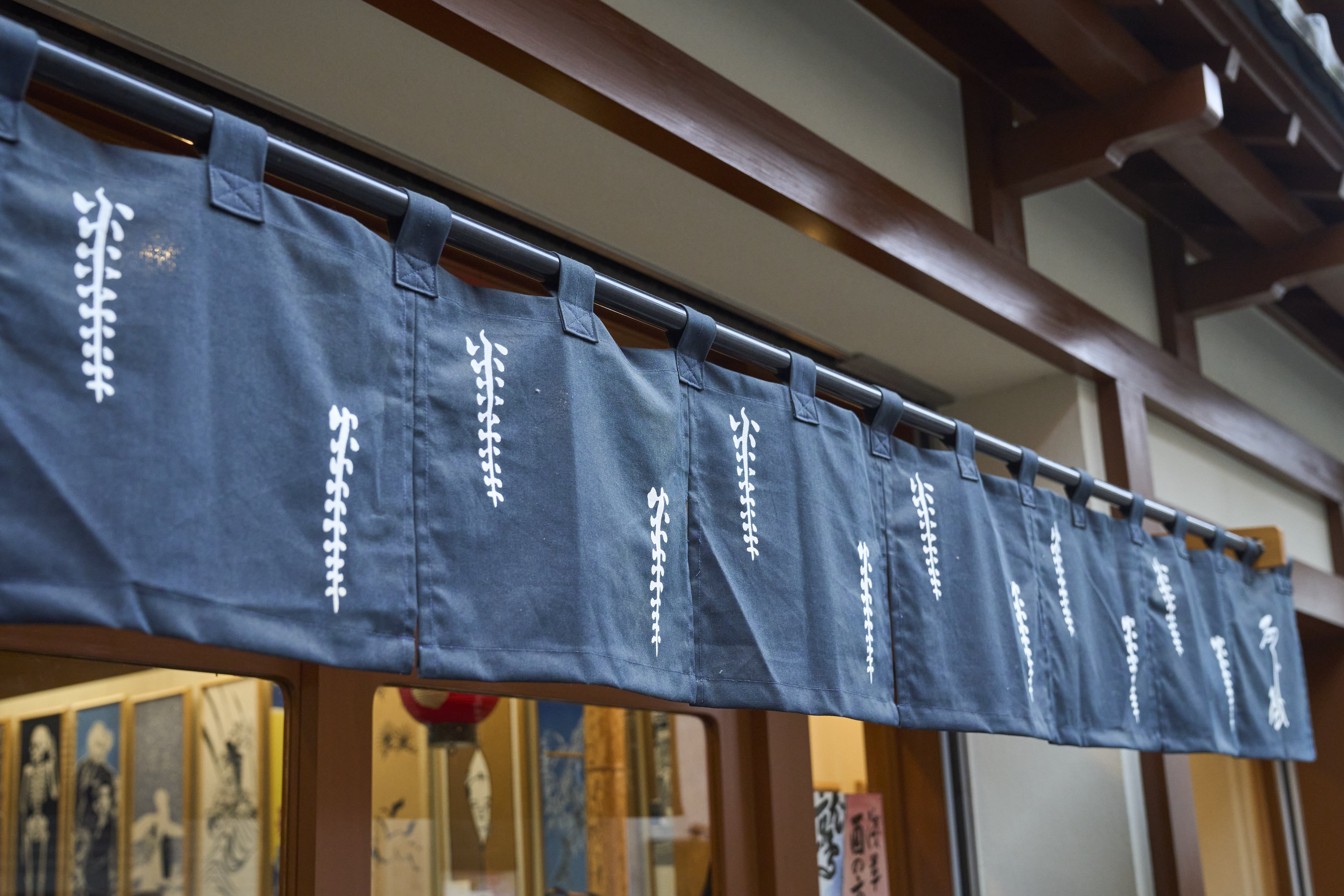 The shop's noren curtains use a playful touch with Japanese characters to suggest <em>itoshii</em> (beloved), forming the name Itoshi Fuji.